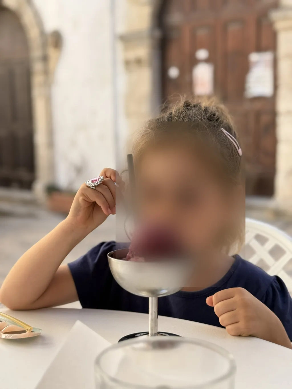 Un bambino mangia il gelato da una coppa al tavolo.