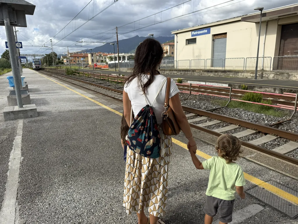 Una donna e un bambino per mano su un binario.