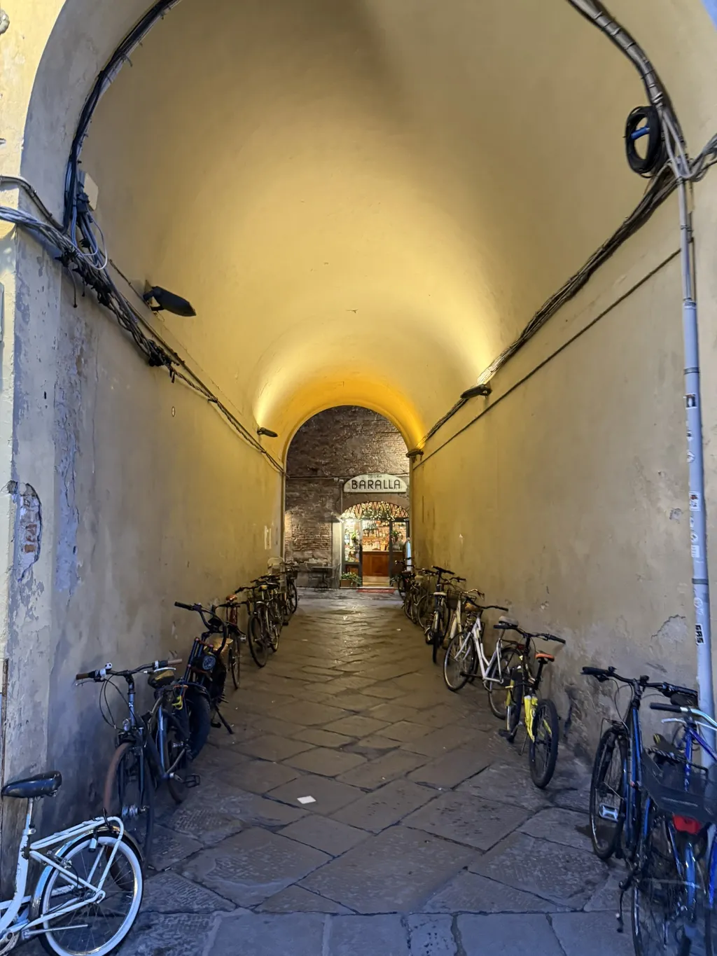 Un passaggio a volta, lungo le pareti sono posteggiate delle biciclette.