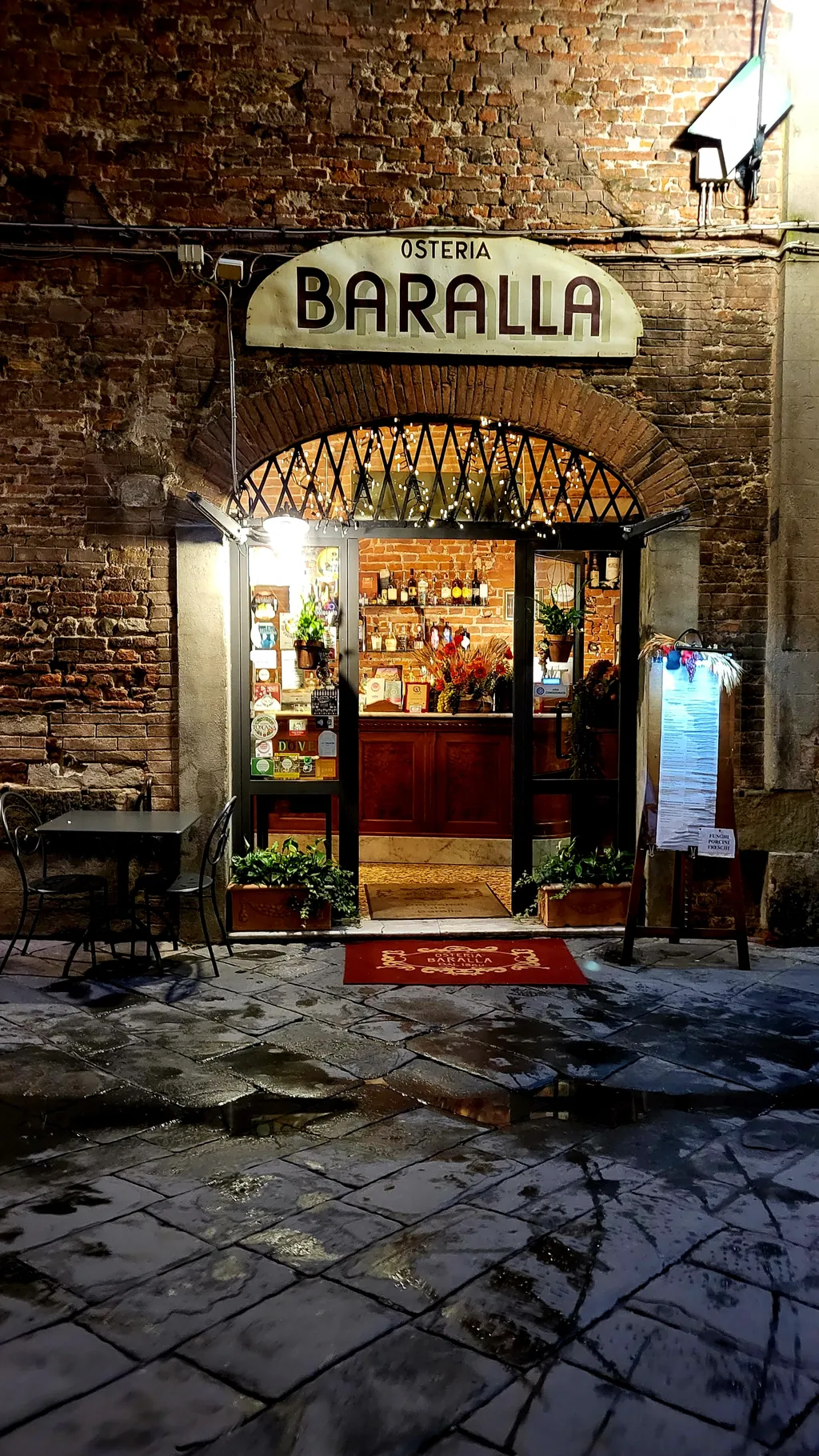 L’ingresso di un’osteria con l’insegna Baralla sopra l’arco.