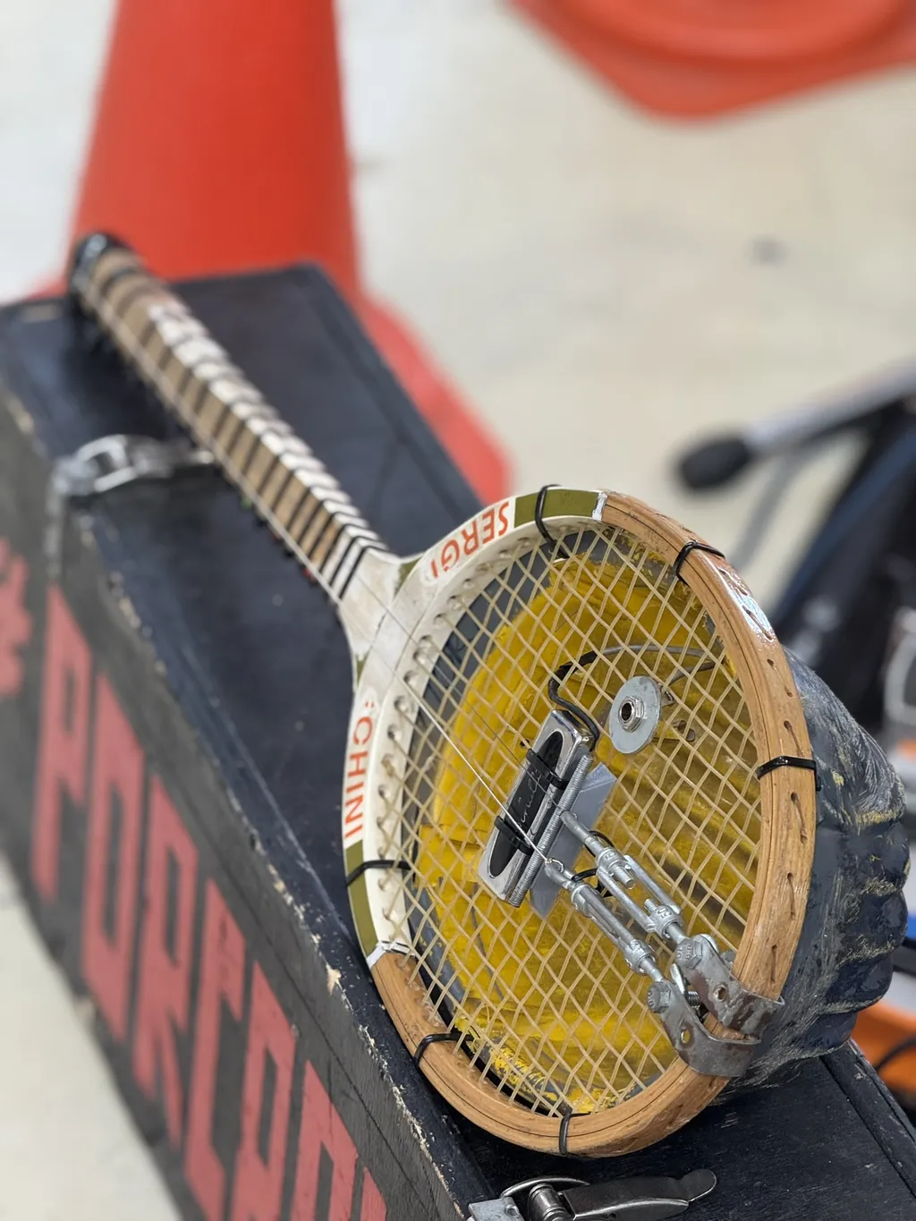 Uno skateboard trasformato in chitarra con una racchetta da tennis come cassa.