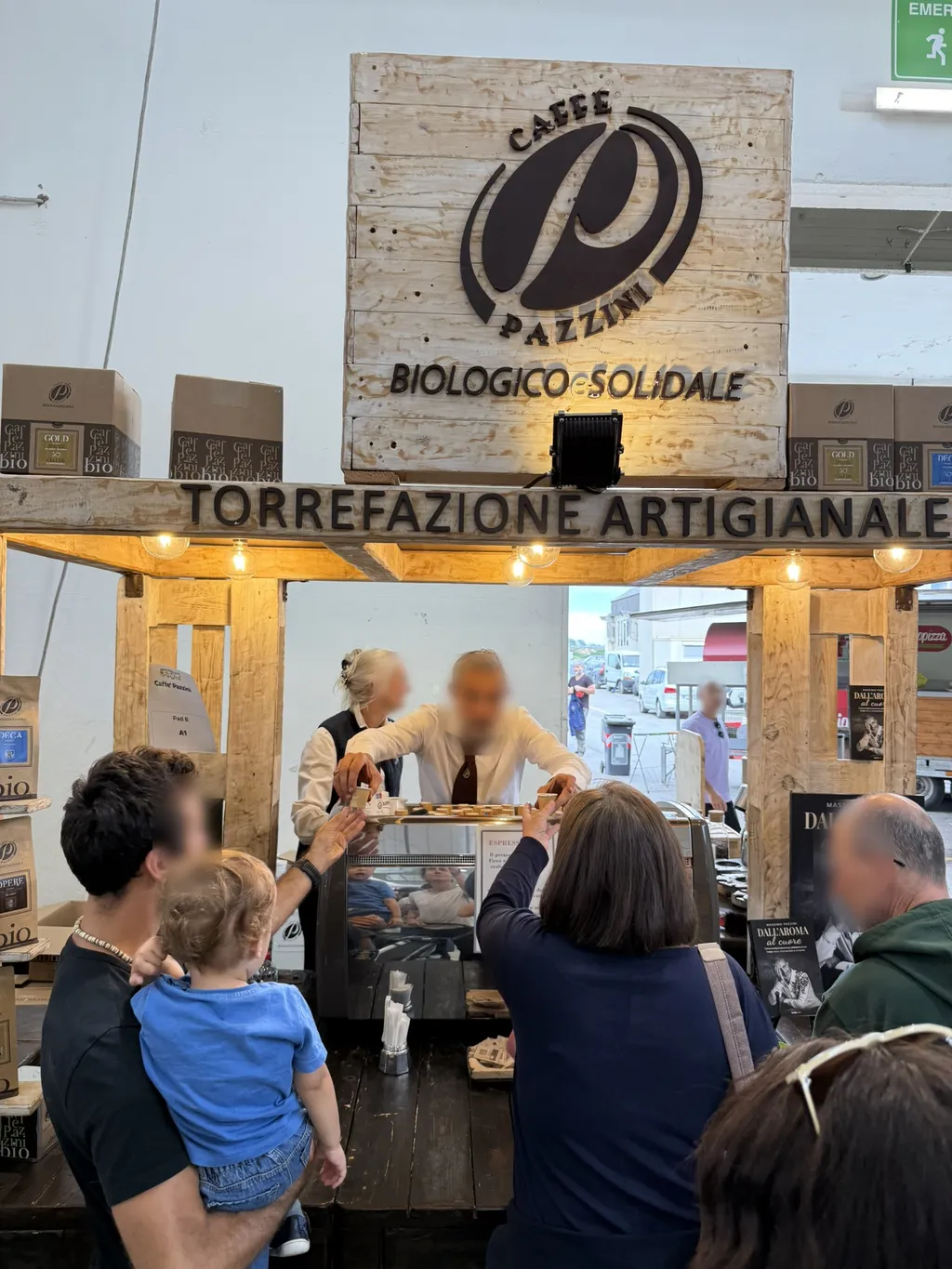 Un banco del caffè in legno, davanti delle persone al bancone.