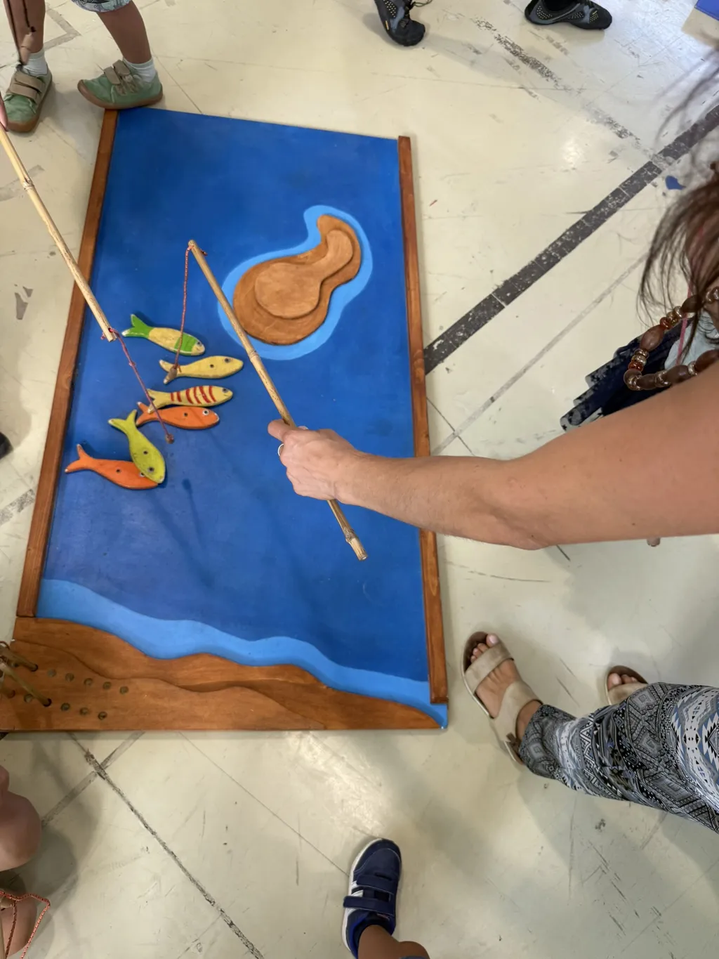 Un gioco di pesca con pesci di legno su una tavola dipinta di blu.