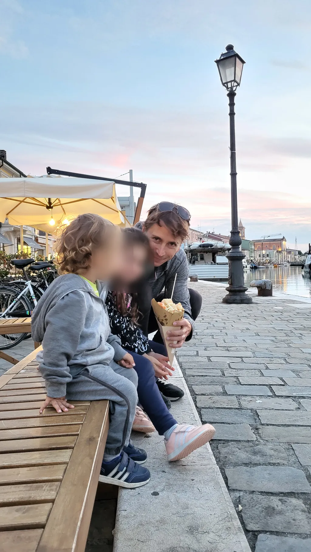 Una famiglia seduta su una passerella di legno lungo il canale.