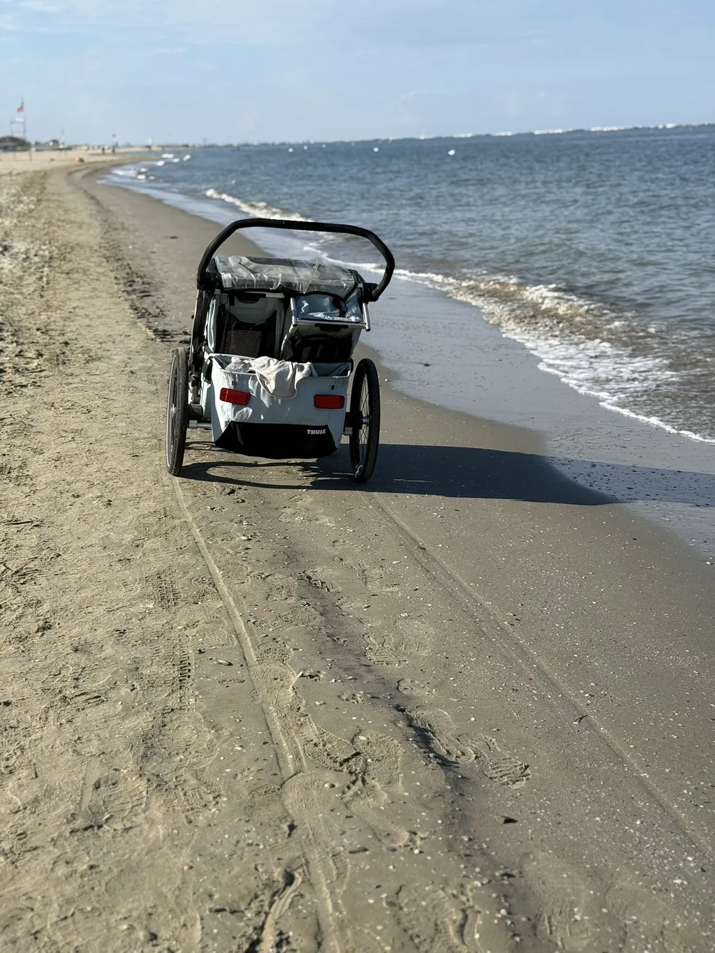 Un rimorchio da bici solo su una spiaggia ampia.