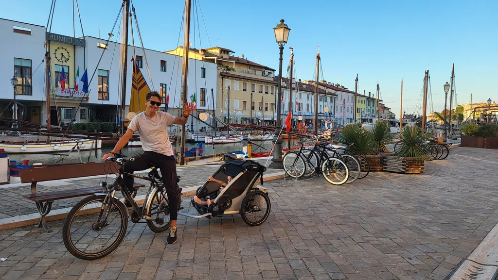 Un uomo in bici con il rimorchio lungo il porto canale.